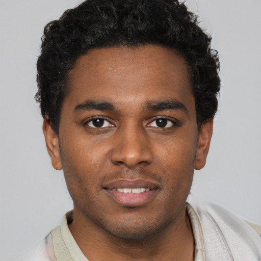 Joyful black young-adult male with short  brown hair and brown eyes
