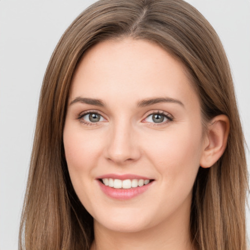 Joyful white young-adult female with long  brown hair and grey eyes