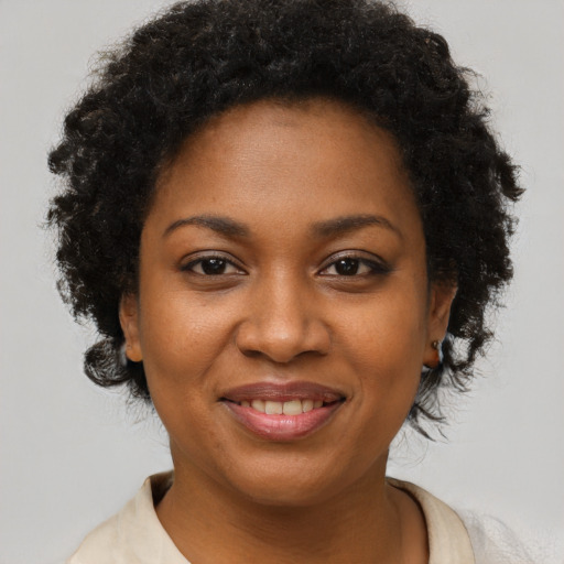 Joyful black young-adult female with short  brown hair and brown eyes