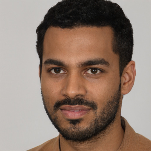 Joyful latino young-adult male with short  black hair and brown eyes