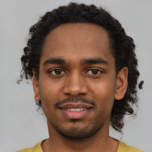 Joyful black young-adult male with short  black hair and brown eyes