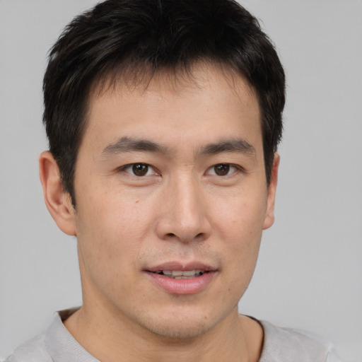 Joyful asian young-adult male with short  brown hair and brown eyes