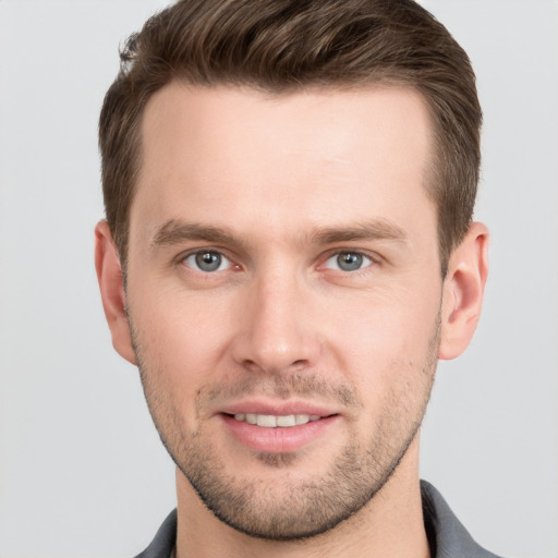 Joyful white young-adult male with short  brown hair and grey eyes