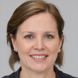 Joyful white adult female with medium  brown hair and grey eyes