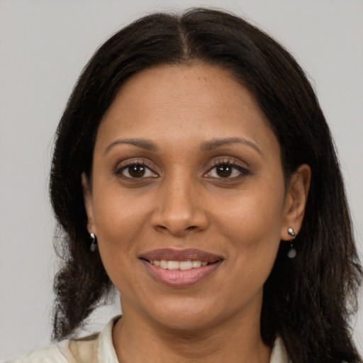 Joyful latino adult female with medium  brown hair and brown eyes