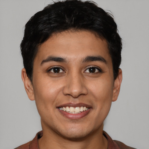 Joyful latino young-adult male with short  black hair and brown eyes