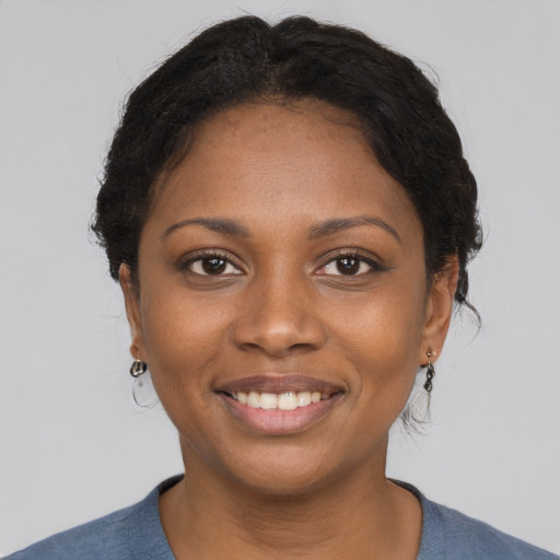 Joyful black young-adult female with short  brown hair and brown eyes