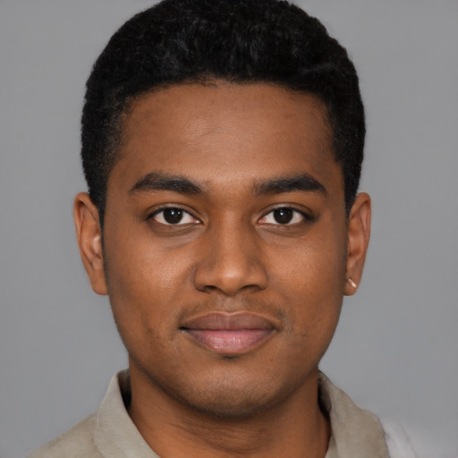 Joyful black young-adult male with short  black hair and brown eyes