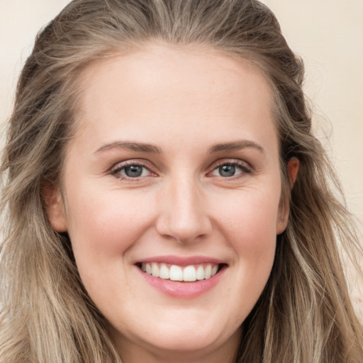 Joyful white young-adult female with long  brown hair and blue eyes