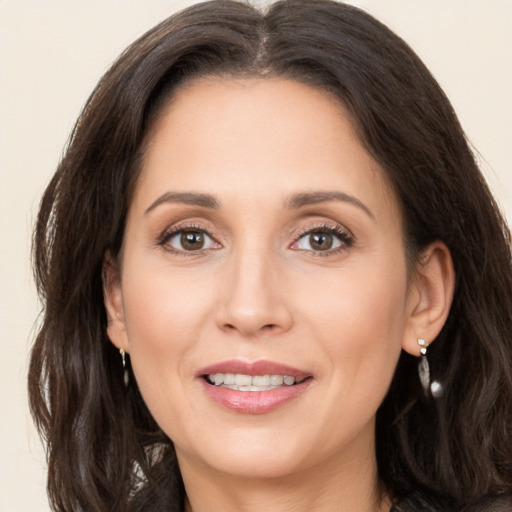 Joyful white adult female with long  brown hair and brown eyes