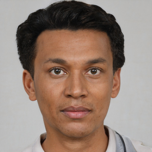Joyful latino young-adult male with short  black hair and brown eyes