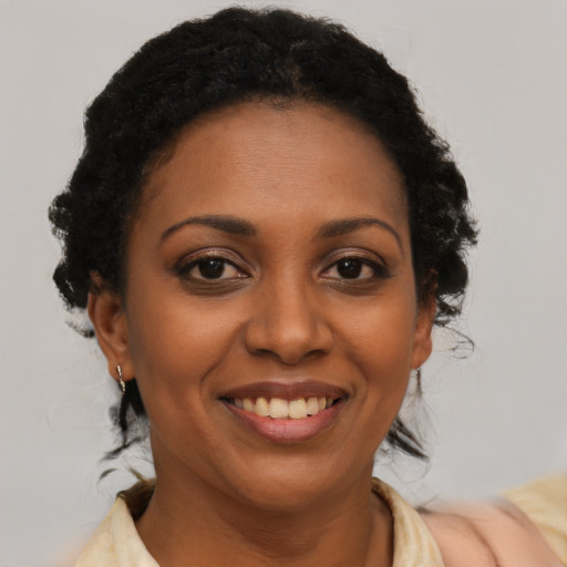 Joyful black adult female with medium  brown hair and brown eyes
