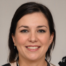 Joyful white adult female with medium  brown hair and brown eyes