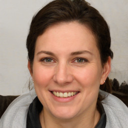 Joyful white adult female with medium  brown hair and blue eyes