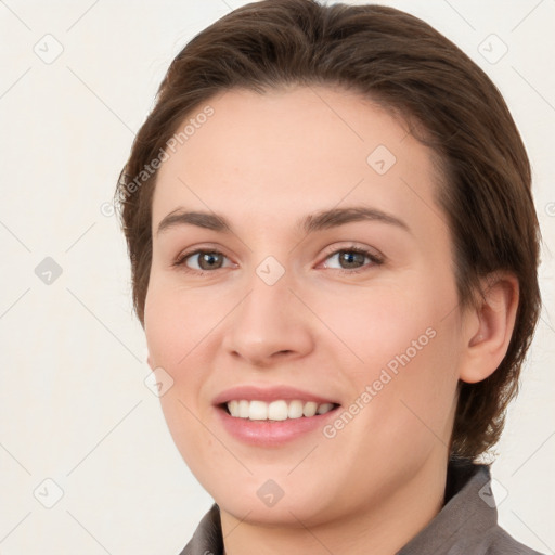 Joyful white young-adult female with medium  brown hair and grey eyes