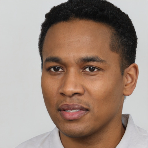 Joyful black young-adult male with short  black hair and brown eyes