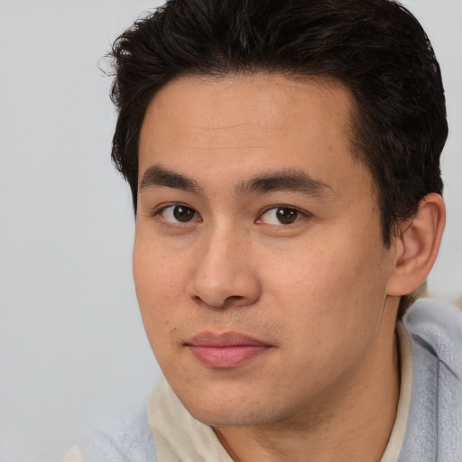 Joyful asian young-adult male with short  brown hair and brown eyes
