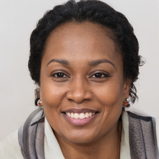 Joyful black adult female with long  brown hair and brown eyes