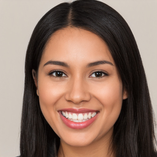 Joyful latino young-adult female with long  black hair and brown eyes