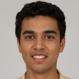 Joyful latino young-adult male with short  black hair and brown eyes