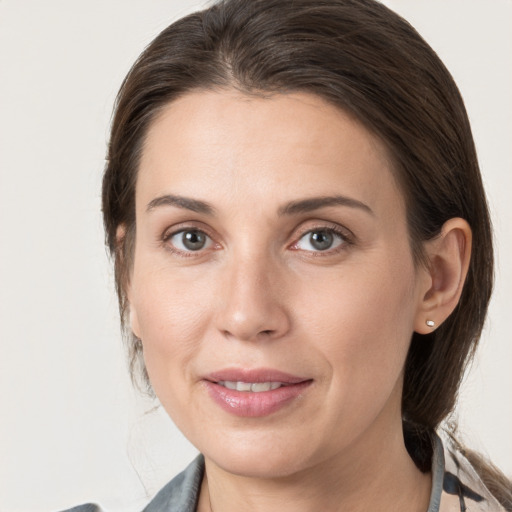 Joyful white young-adult female with medium  brown hair and grey eyes