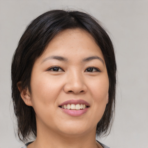 Joyful asian young-adult female with medium  brown hair and brown eyes