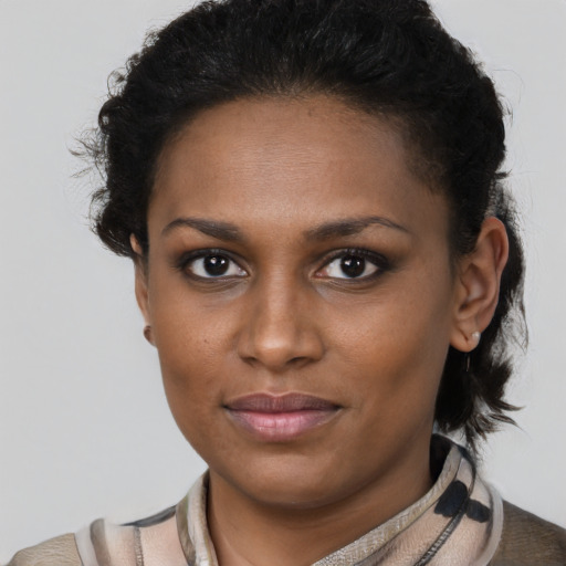 Joyful black young-adult female with short  brown hair and brown eyes