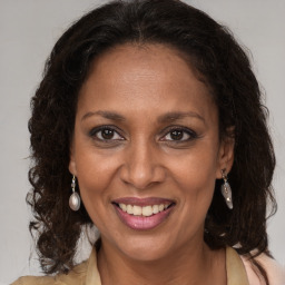 Joyful latino adult female with medium  brown hair and brown eyes