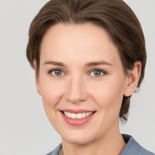 Joyful white young-adult female with medium  brown hair and grey eyes