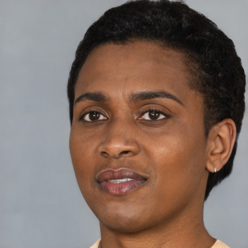 Joyful black young-adult female with short  black hair and brown eyes