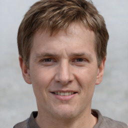 Joyful white adult male with short  brown hair and grey eyes