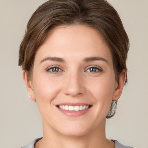 Joyful white young-adult female with short  brown hair and grey eyes