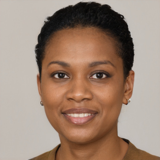 Joyful black young-adult female with short  black hair and brown eyes
