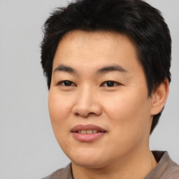 Joyful asian young-adult male with short  black hair and brown eyes