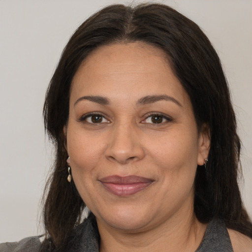 Joyful latino adult female with medium  brown hair and brown eyes