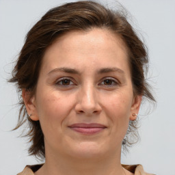 Joyful white adult female with medium  brown hair and brown eyes