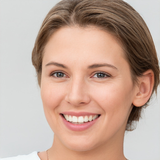 Joyful white young-adult female with medium  brown hair and grey eyes