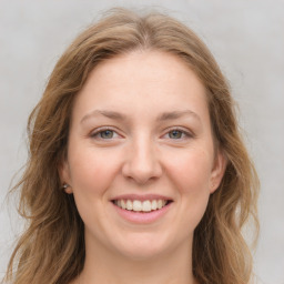 Joyful white young-adult female with long  brown hair and green eyes