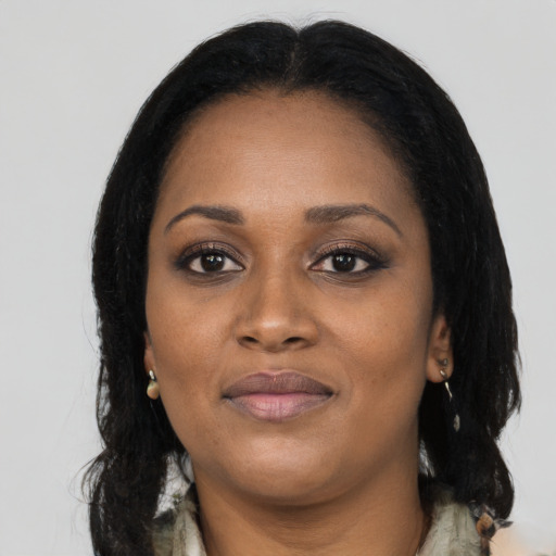 Joyful black young-adult female with long  black hair and brown eyes