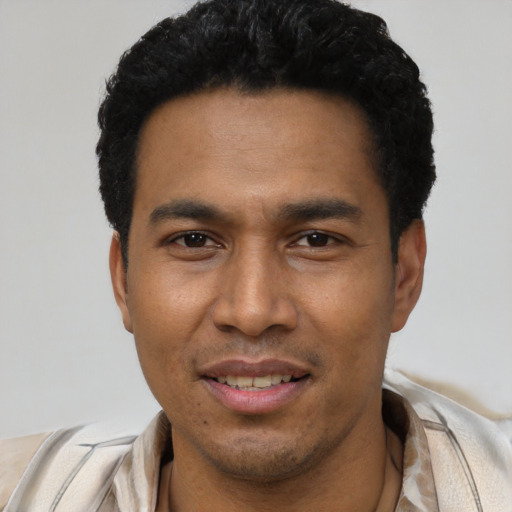 Joyful latino young-adult male with short  black hair and brown eyes
