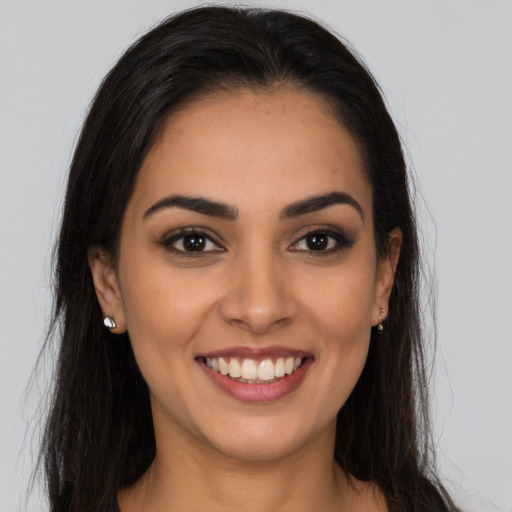 Joyful latino young-adult female with long  brown hair and brown eyes