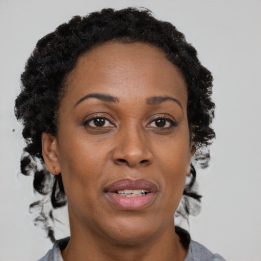 Joyful black adult female with medium  brown hair and brown eyes