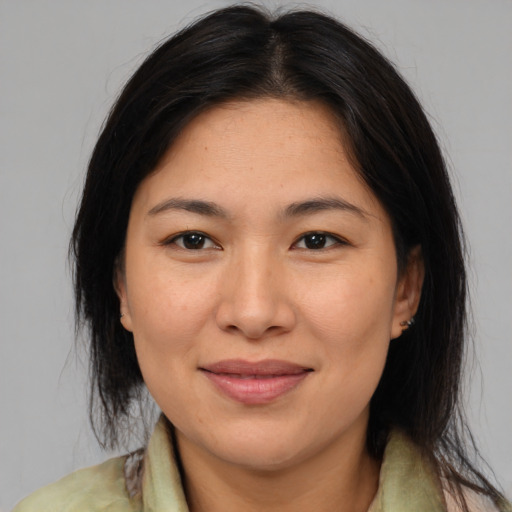 Joyful asian adult female with medium  brown hair and brown eyes