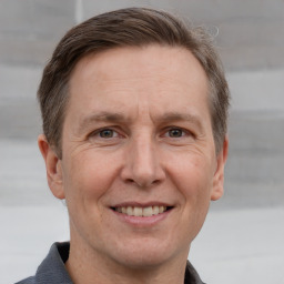 Joyful white adult male with short  brown hair and grey eyes