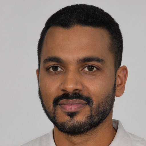 Joyful black young-adult male with short  black hair and brown eyes