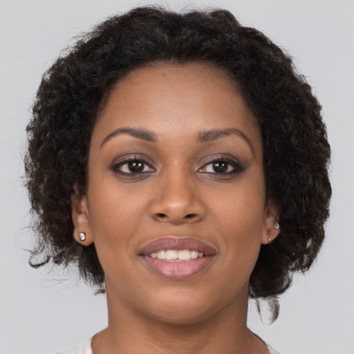 Joyful black young-adult female with long  brown hair and brown eyes