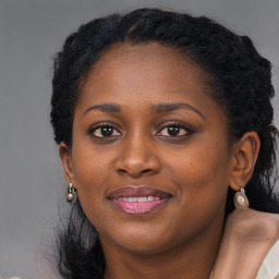 Joyful black young-adult female with long  black hair and brown eyes