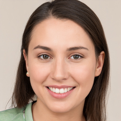 Joyful white young-adult female with long  brown hair and brown eyes