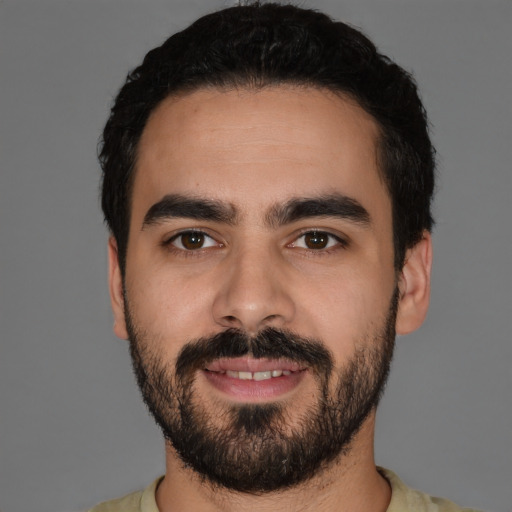 Joyful latino young-adult male with short  black hair and brown eyes