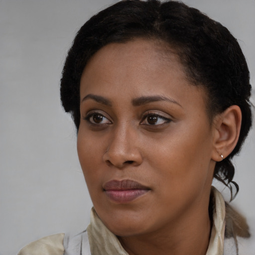 Joyful black young-adult female with short  brown hair and brown eyes